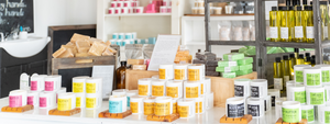 Salt Spray Soap Co products on a table their store in St. George's Bermuda. Soap, Body Butter, Body Oil, Salt Scrub, and Soap. All handmade right there in the store and available in 6 different scents as well as unscented.
